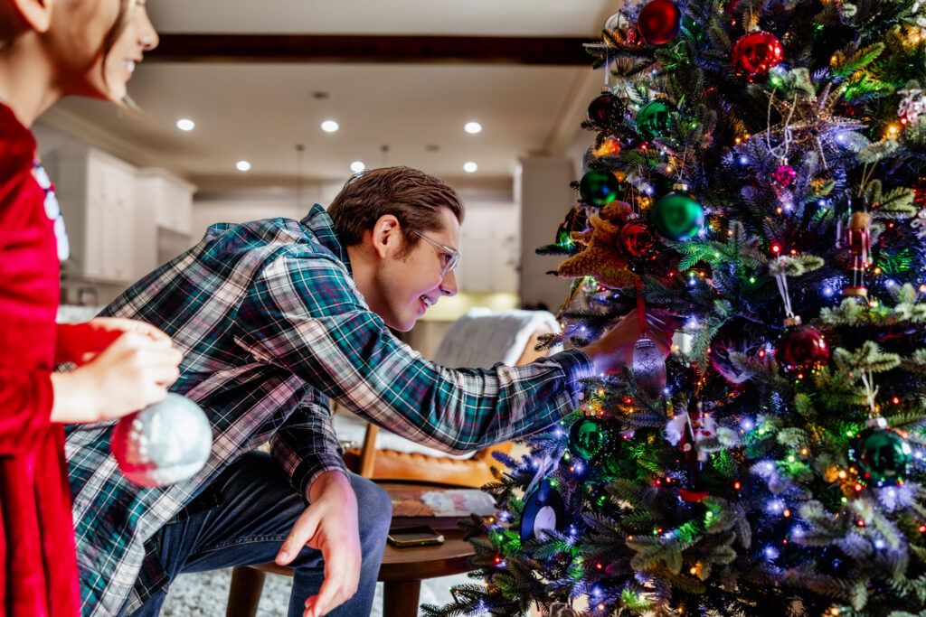 Dad trying to get the cat out of the Christmas tree during a Houston Christmas Mini session