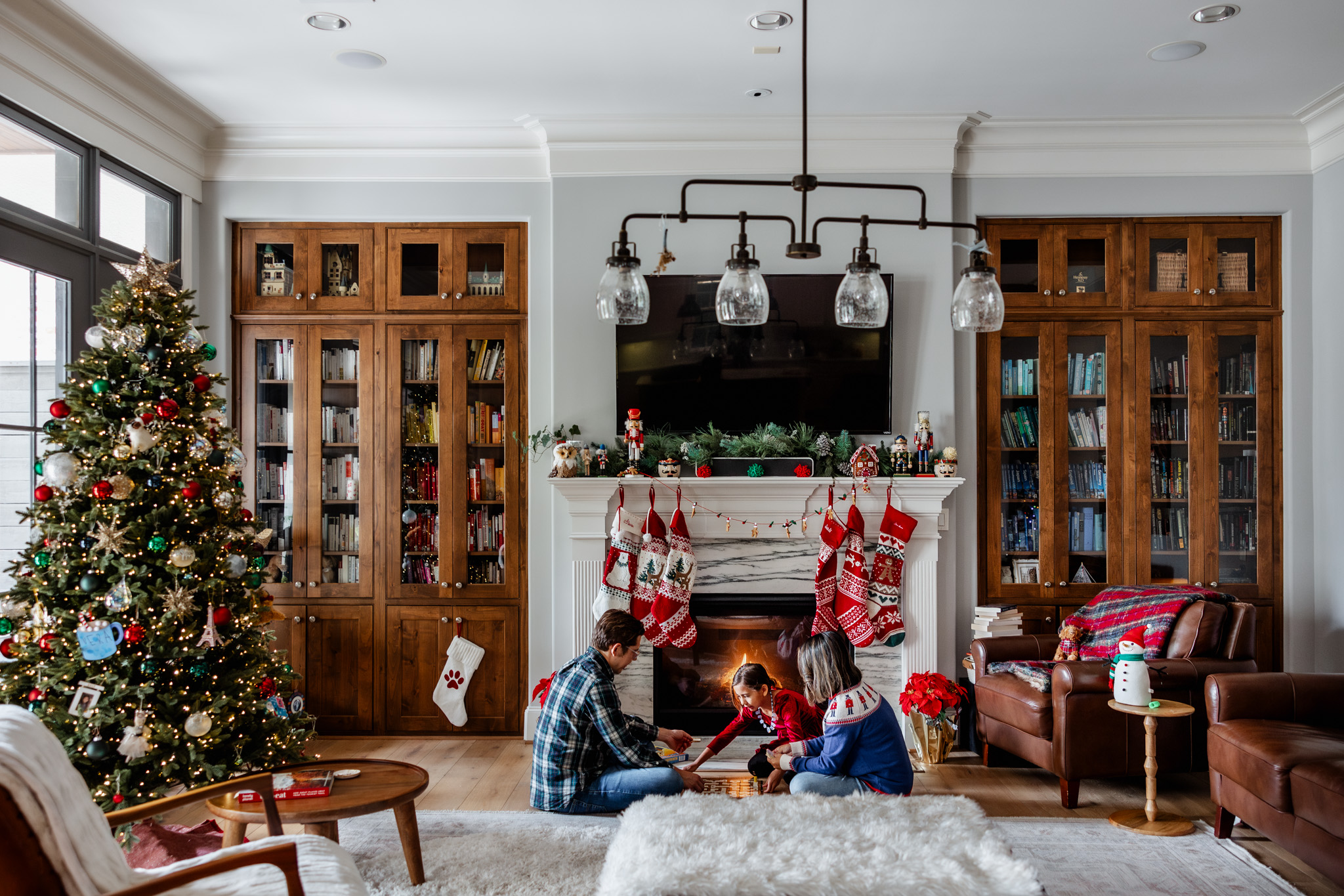 Family playing board game in front of a fireplace during a documentary style Christmas mini session