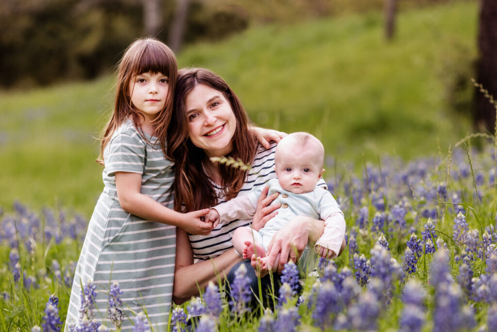 Mother and children smiling in a bluebonnet field in West Houston
